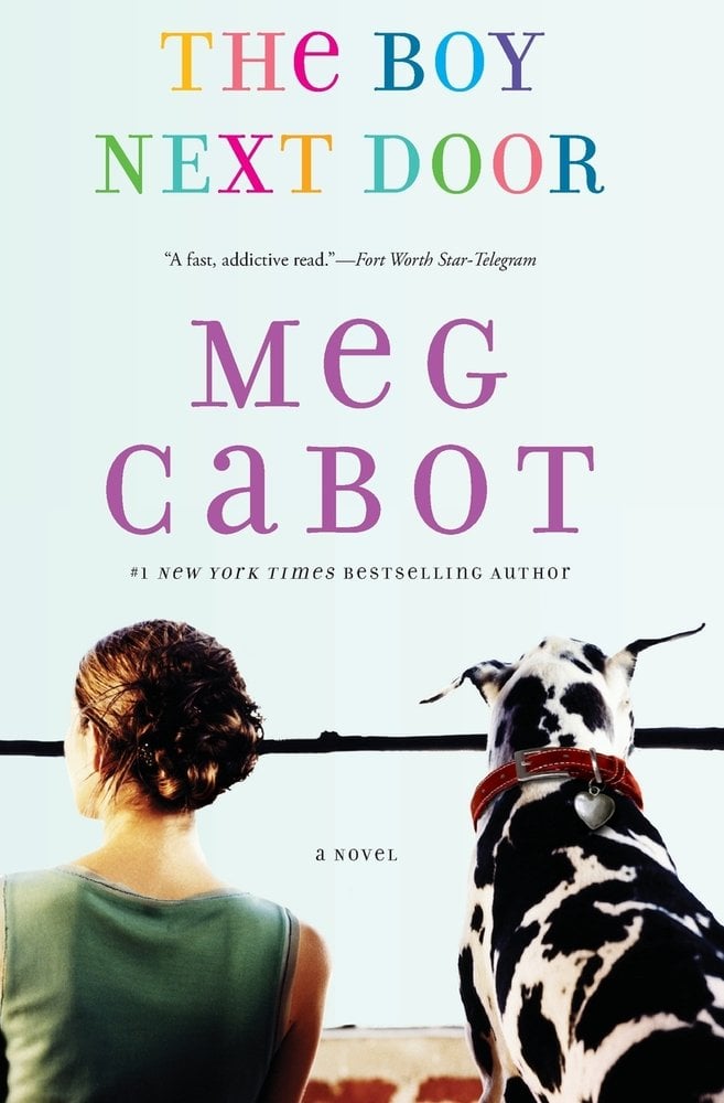 The Boy Next Door by Meg Cabot, a romance book cover depicting a girl with an updo hairstyle wearing a green shirt (on the left) and a dalmatian dog with a red color (on the right), both facing away from the front cover. The title is printed in a multi color font, and the author's name is printed in a bold purple font.