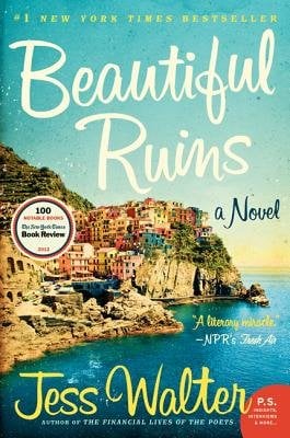 A small Italian village on the coastline against a sunny sky.