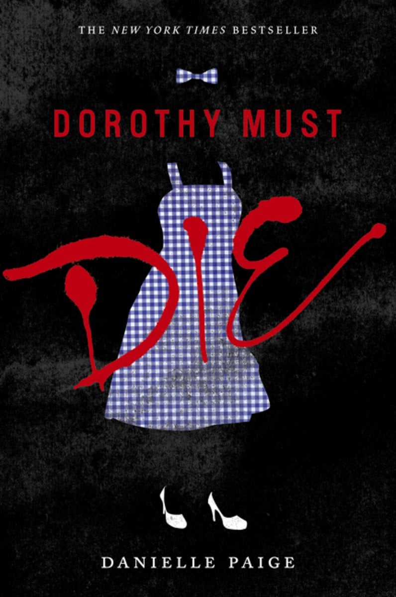 Dorothy Must Die by Danielle Paige, a YA fantasy novel cover, depicts a black cover with a blue gingham dress, bow, and white heels. The word "die" in large letters written diagonally along the cover.