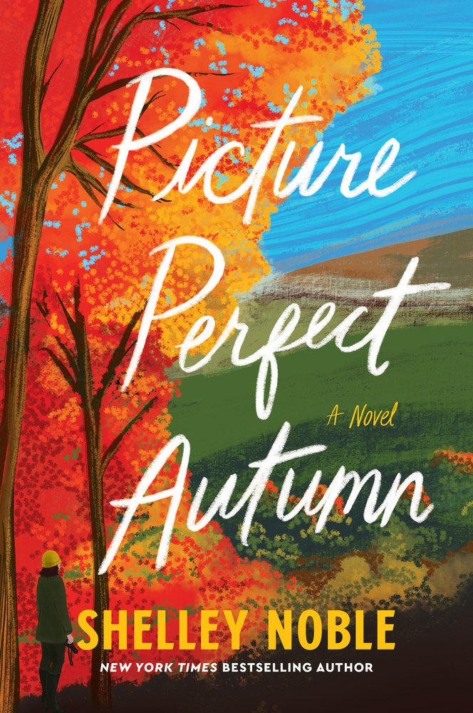 Picture Perfect Autumn by Shelley Noble book cover featuring a landscape scene. On the left are vivd, orange tress with a sole person standing, looking out on the landscape. They're wearing a yellow beanie, and green coat. The sky is a bright blue with rolling green hills. The title appears in white script across the screen and the author's name at the very bottom in all yellow caps.