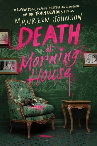 A green wallpaper shows the outline of a houce surrounded by trees. Picture frames are on the wall and an old green chair is in the center, with a black camera and pink lipstick stains. the lipstick is on a table next to the chair and words have been written on the wall using the bright pink makeup.
