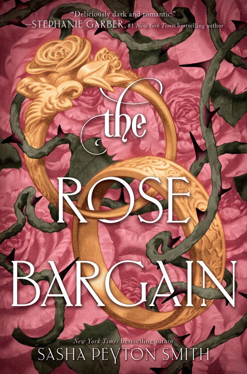 The cover of The Rose Bargain by Sasha Peyton Smith, a fae romantasy novel, features two entwined gold rings with rose vines tangled around them. The background is pink roses.