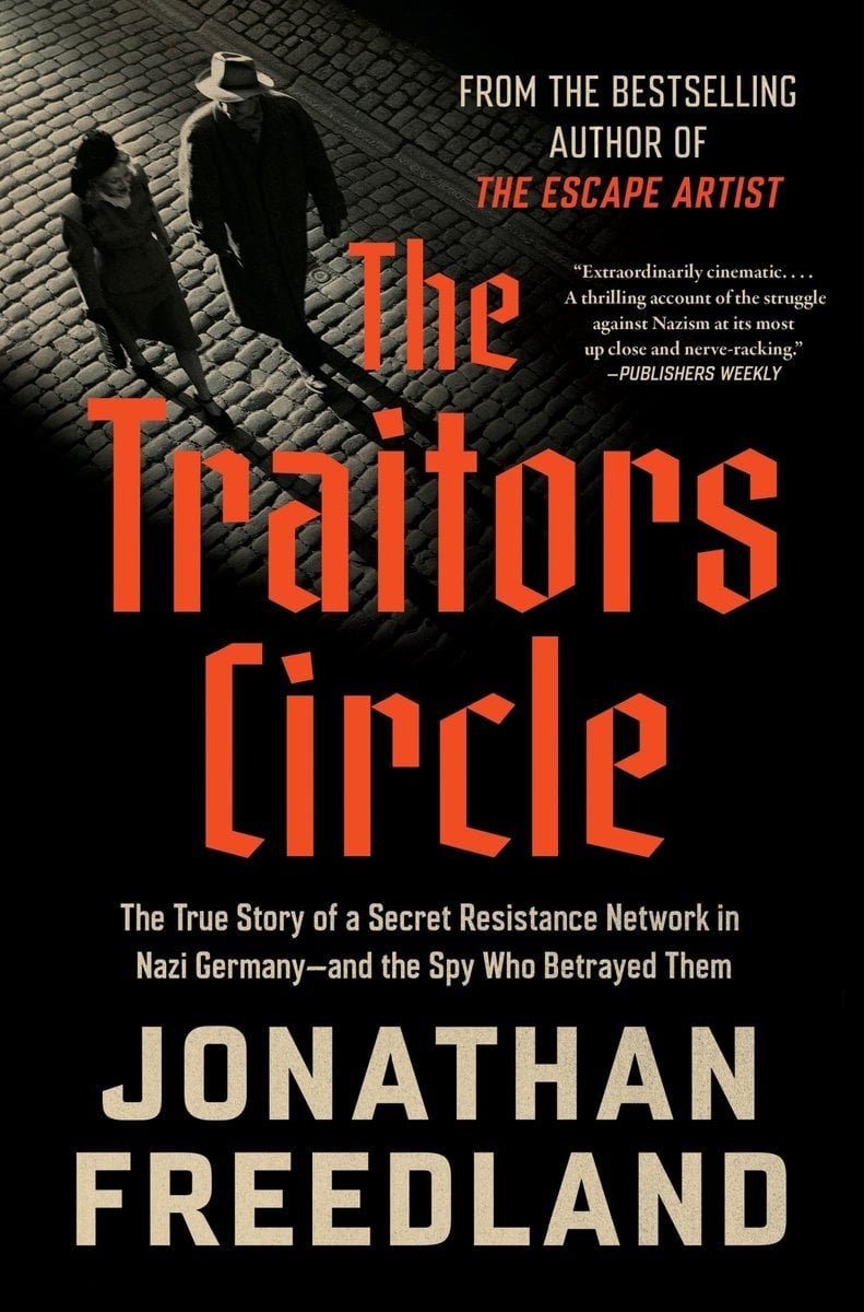 The Traitors Circle: The True Story of a Secret Resistance Network in Nazi Germany - and the Spy Who Betrayed Them by Jonathan Freedland. Two figures walk side by side down a cobbled, dimly lit street, their long shadows stretching behind them.