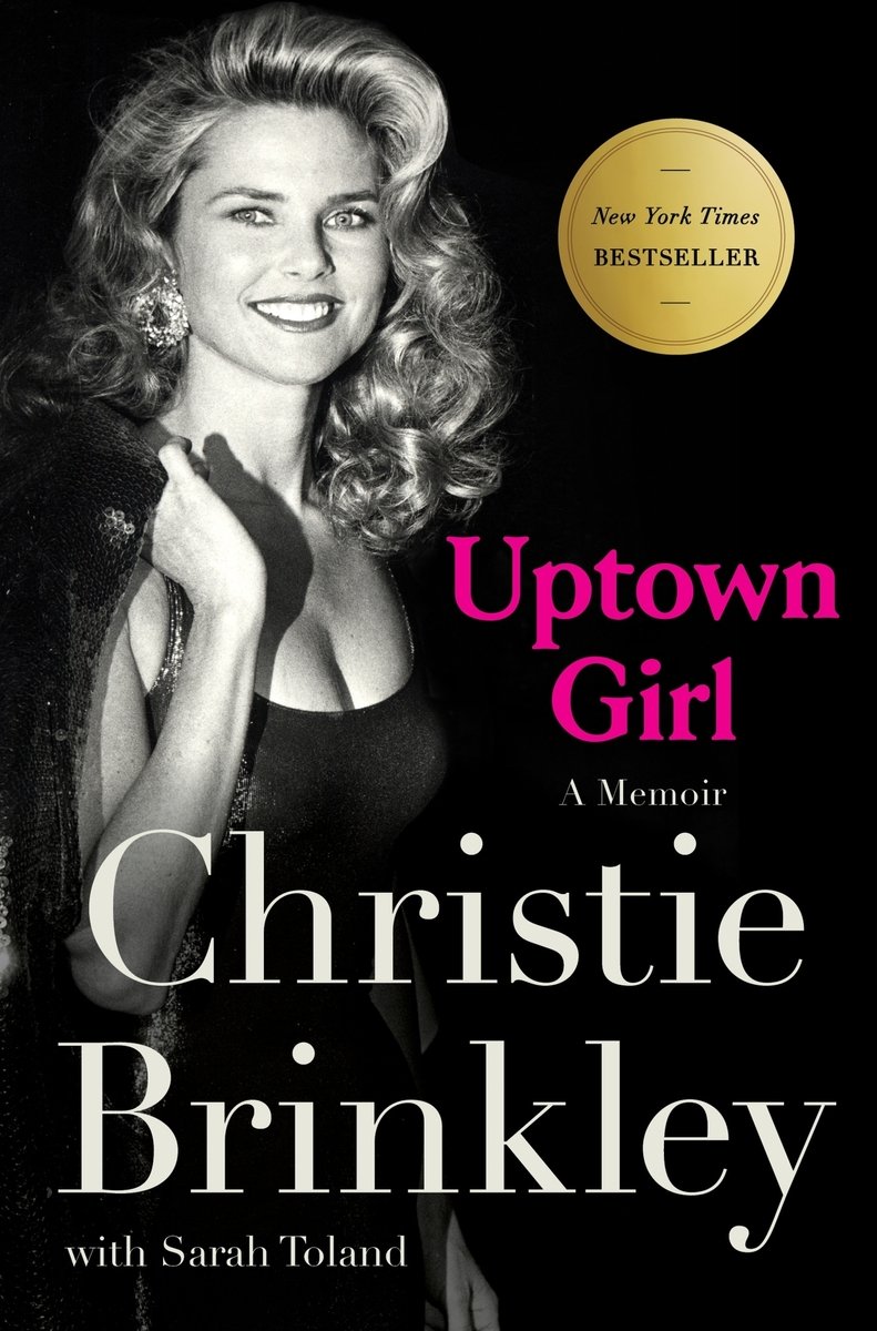 The book cover for Uptown Girl by Christie Brinkley. A black background with a black and white photograph of a young Christie Brinkley wearing a black dress and big sparkling earrings. The title is in dark pink text.
