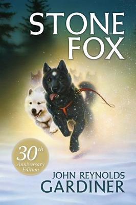 The book cover for Stone Fox' by John Reynolds Gardiner. A black wolf husky-like dog runs through snow, with other huskies close behind.