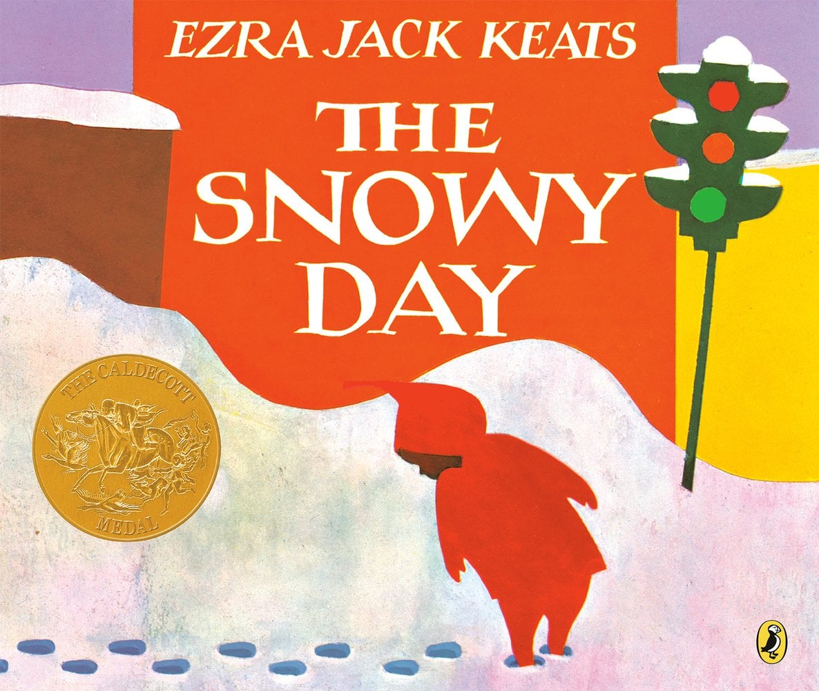The Snowy Day by Ezra Jack Keats book cover features a little boy dressed in all red looking back behind him at his footprints he's leaving in the snow. It appears to be set on a snowy street with the base of a traffic light covered in snow all the way up to where only a portion of a brick wall is showing. The title is in all white, caps in the center of the book with the author's name at the very top.