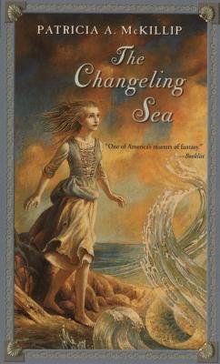 The Changeling Sea by Patricia A. McKillip book cover. A woman stands on the rocks with the wind blowing her hair and dress behind her as she takes a step towards the sea, which waves up towards her.