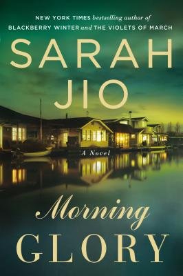 Morning Glory by Sarah Jio book cover featuring a a lakehouse at night with the house reflecting off the lake.