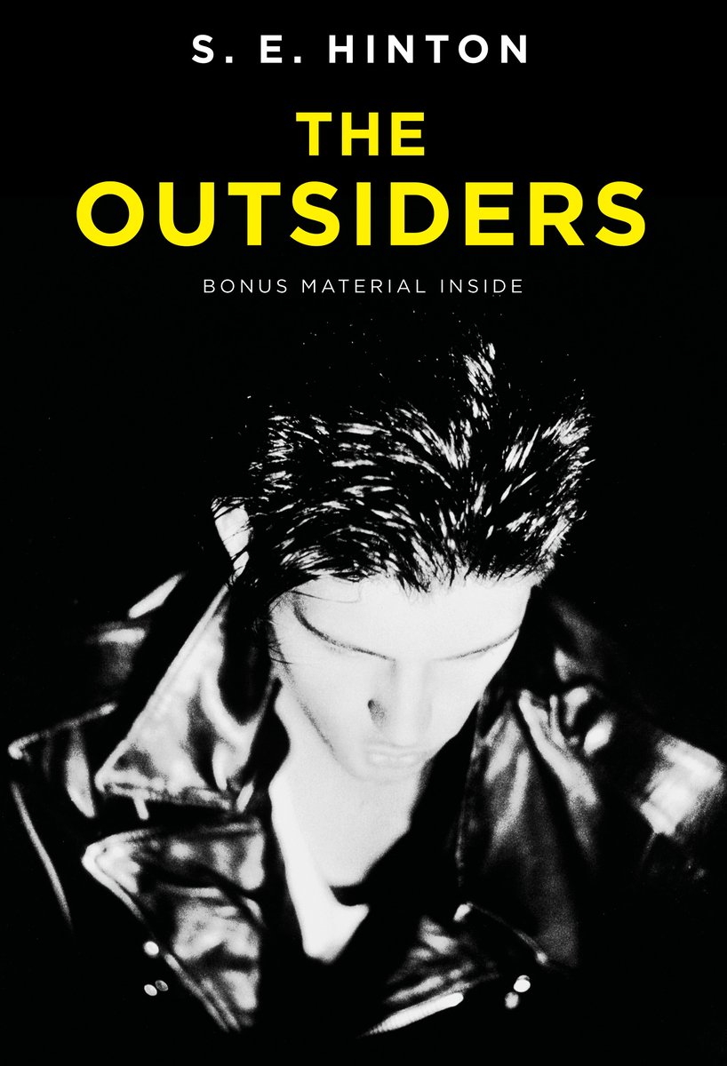 The Outsiders by S.E. Hinton, book cover. Depicting a man in black and white, wearing a leather, high-collared jacket, with his head down so we cannot see his face clearly.