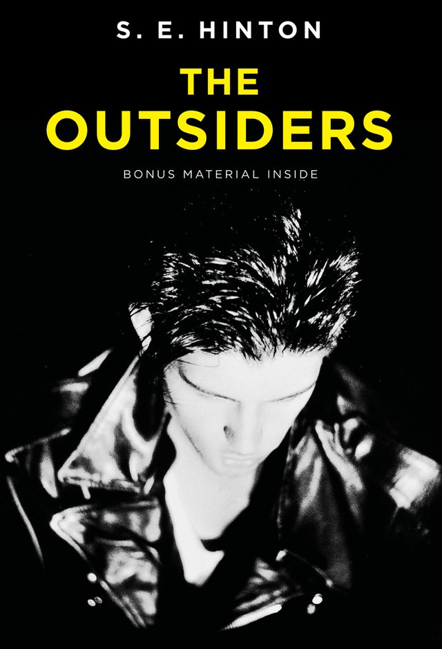 The Outsiders by S.E. Hinton shows a boy in black and white looking down to show his slicked back hair and leather jacket.