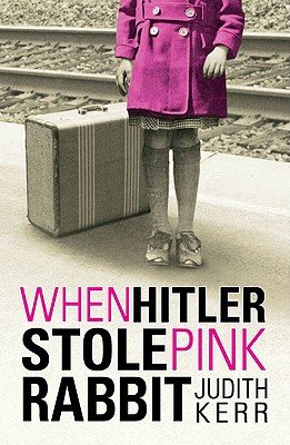 When Hitler Stole Pink Rabbit by Judith Kerr middle-grade book cover depicting the bottom half of a girl waiting at the train station with her suitcase. The entire picture is black and white except for the girl's overcoat, which is pink.