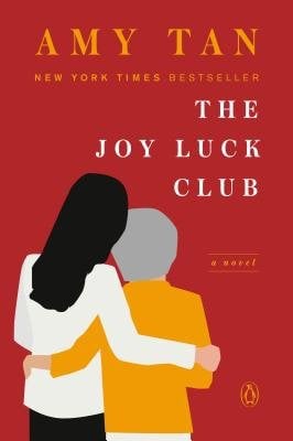 The Joy Luck Club by Amy Tan, a book cover depicting a young woman and older woman hugging on a red background
