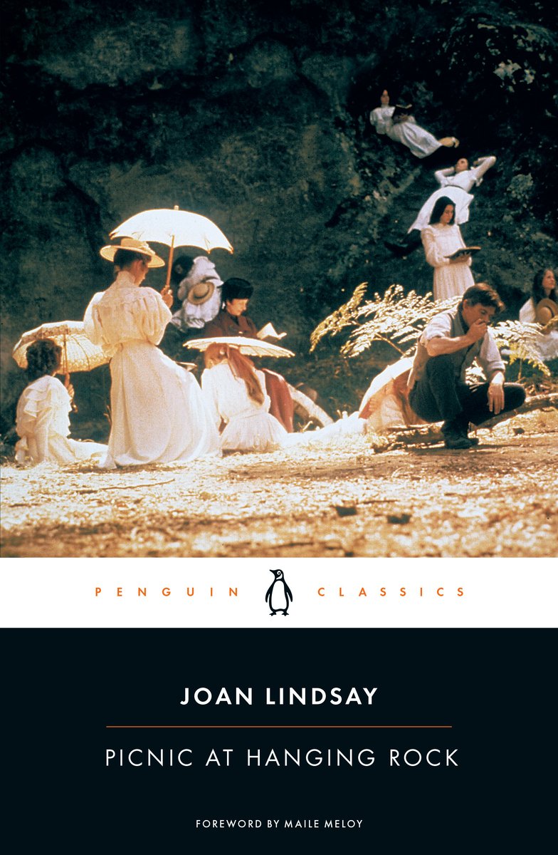 Cover of Picnic at Hanging Rock by Joan Lindsay. The top two thirds of the cover is a group of people having a picnic and wearing historical period style clothing. The bottom third is the author's name and title against a black background.