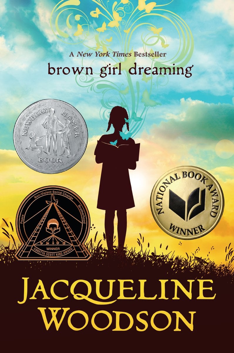 Brown Girl Dreaming by Jacqueline Woodson middle grade poetry book depicting the silhouette of a young girl against a blue and yellow sky on a grassy field.