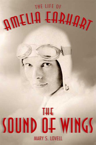 Close up photo of Earhart with goggles and hat on, in the clouds.