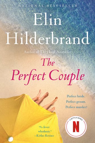 The Perfect Couple by Elin Hilderbrand, book cover. Two pairs of legs stick out under a yellow umbrella on the beach, by the water.