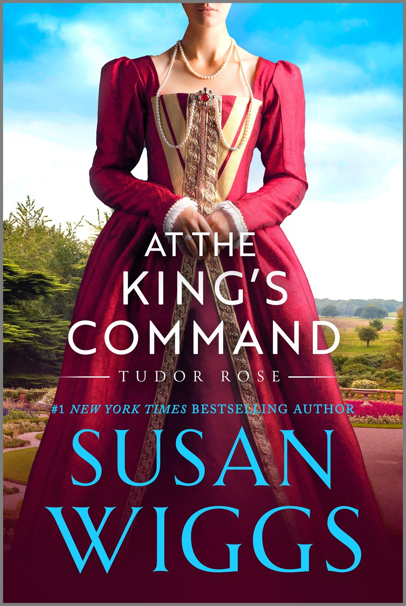 At the King's Command by Susan Wiggs, a historical romance book cover depicting a woman standing outside surrounded by trees, with her hands held in front of her. She is wearing a red gown with gold accents and pearl jewelry.