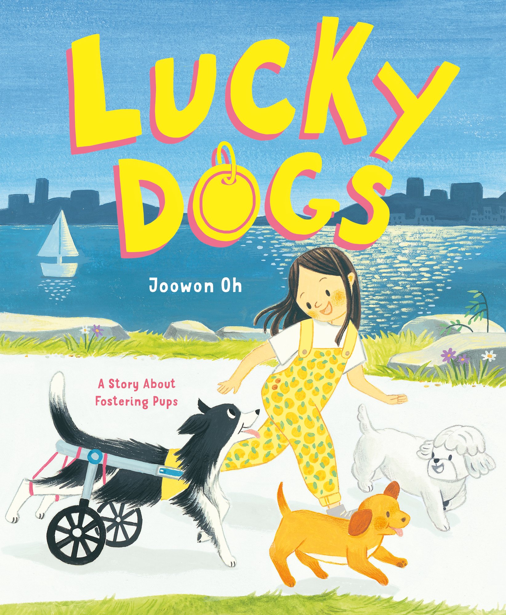 Book cover for Lucky Dogs by Joowon Oh. A girl with black hair wearing yellow patterned overalls and a white shirt runs on a white path flanked by green grass. Three dogs run alongside her: a black dog with its back two legs strung by red bands connected to two wheels, an orange dog and a white dog with a curly coat. The title is in yellow with a gold dog tag in place of the o in dogs. In the background of the cover is a city skyline, a dark blue sky and water with a white boat.
