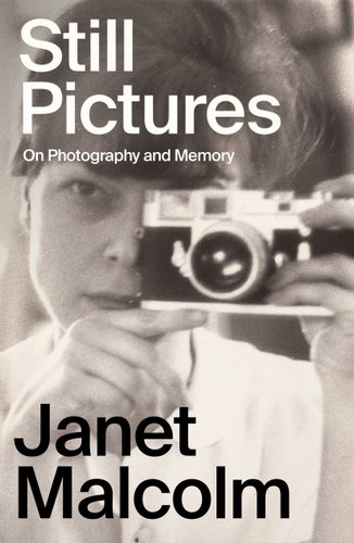 Book cover for Janet Malcolm's Still Pictures with black and white text on top of a black and white photograph of Malcolm aiming a camera