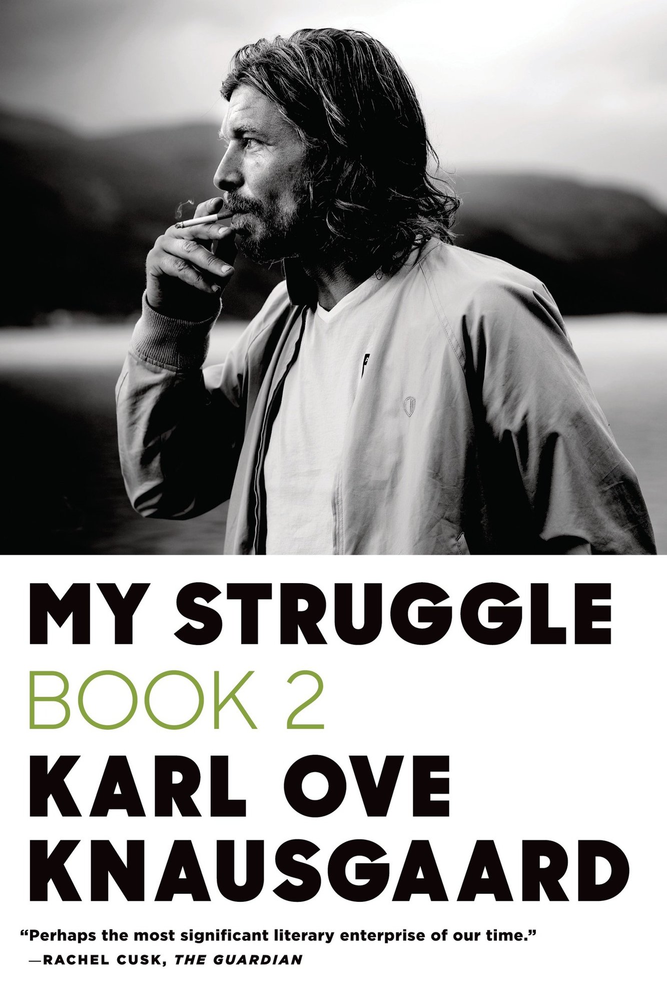 The book cover for My Struggle: Book Two by Karl Ove Knausgaard. The top half is a black and white image of a man wearing a white shirt and pale jacket and smoking a cigarette. The bottom half is a white background with the title in black and green text.