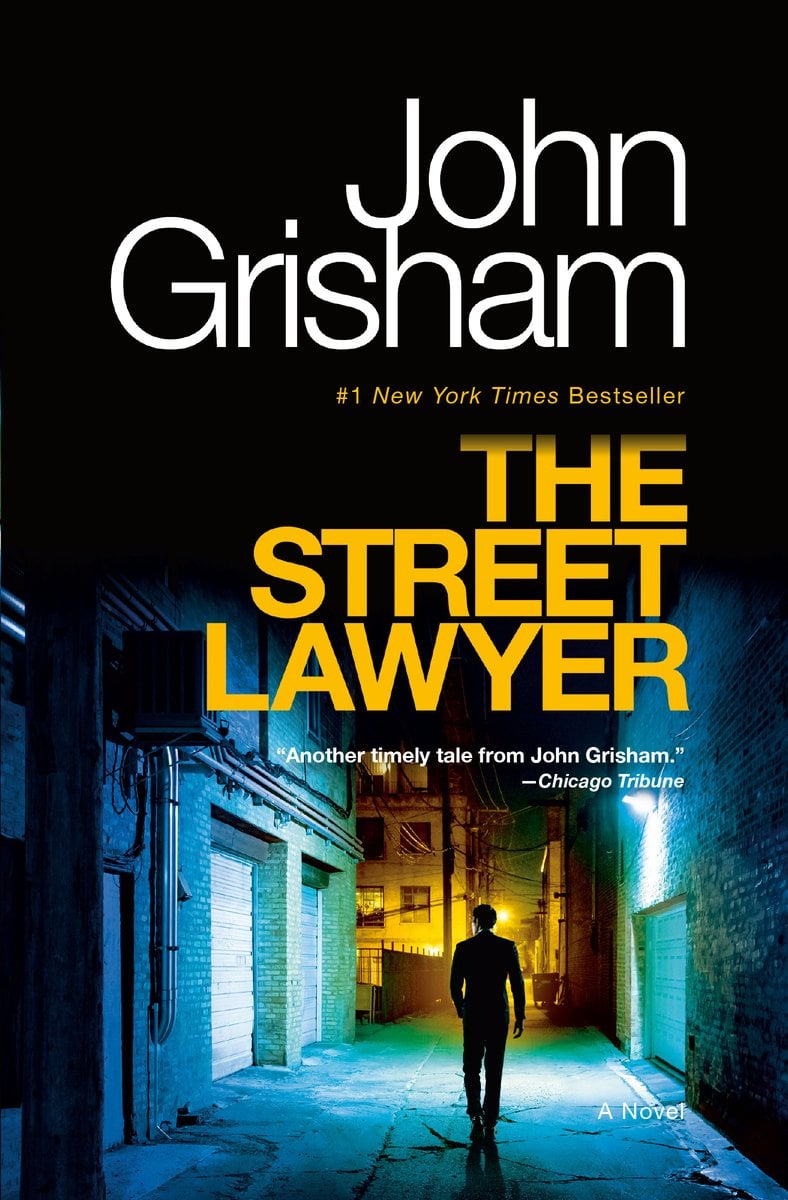 The Street Lawyer by John Grisham. The top half of the cover is black, and the bottom is a man in a blue-lit alleyway walking away into a yellow-lit street.