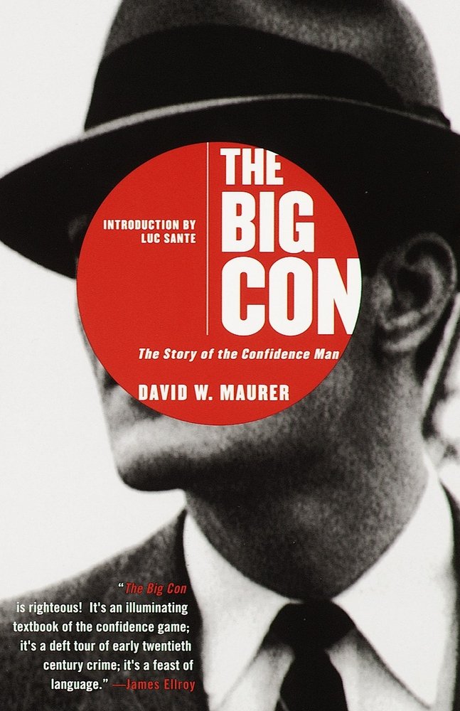 The Big Con: The Story of the Confidence Man by David Maurer book cover depicting an up close headshot of a man dressed in a suit and tie, wearing a hat in black and white. Covering his face is a red circle with the title and author in white text.