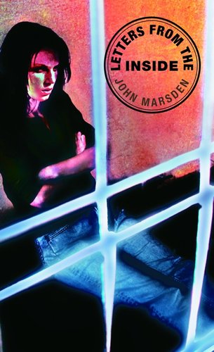 A person locked behind bars with an upset face.