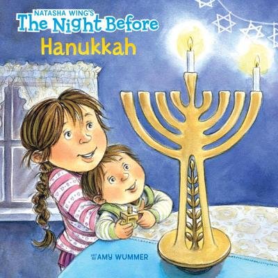 Book cover of "Natasha Wing's The Night Before Hanukkah," illustrated by Amy Wummer, featuring an illustration of two white children embracing while looking up at a menorah with the center candle and first candle lit.