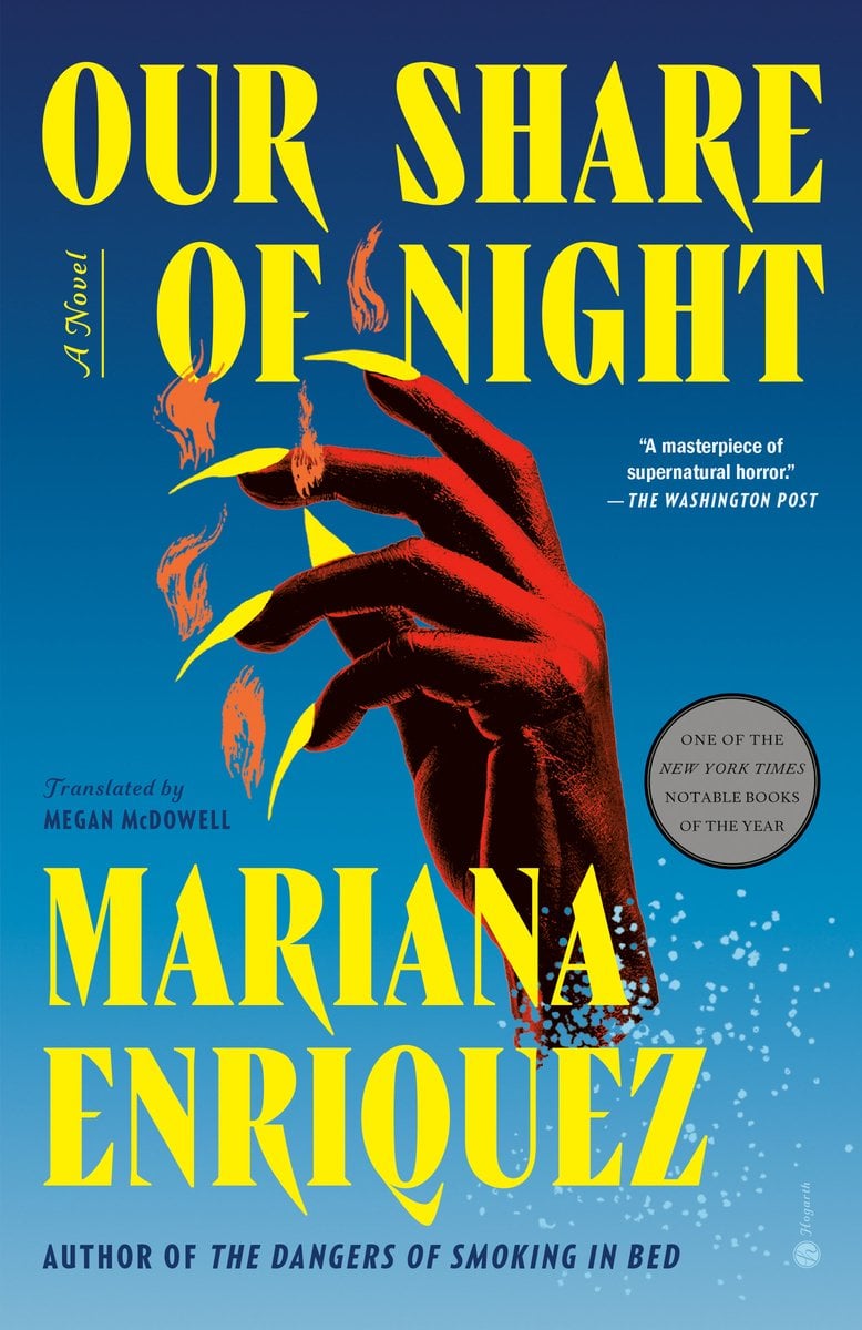 Book cover of Our Share of Night by Mariana Enríquez, translated by Megan McDowell. The design shows a red hand with long yellow nails reaching upward against a blue background, with fire and smoke surrounding the fingers. A circular badge notes it as one of The New York Times Notable Books of the Year.