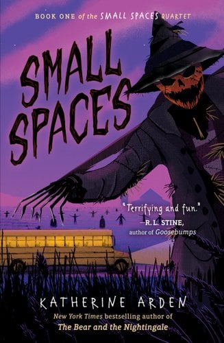 The cover for Small Spaces by Katherine Arden. In the foreground are some dark and twisty trees framing the cover and spelling out the title, small spaces. There is scarecrow looking monster peeking out. In the middle ground is a school bus, and behind it a purple tinted field containing loads of scarecrows and other figures. Behind in the background, you can see the outline of a farmhouse and a silo covered in a pink mist.