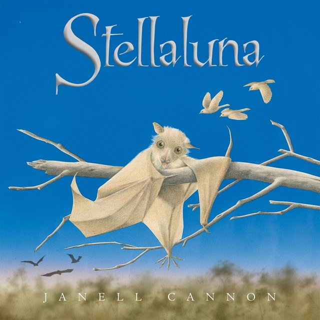 Stellaluna by Janell Cannon, book cover. Sky blue background with blurred out trees underneath in the distance, a white fruit bat lays on a tree branch, white birds and and black bats in the background.