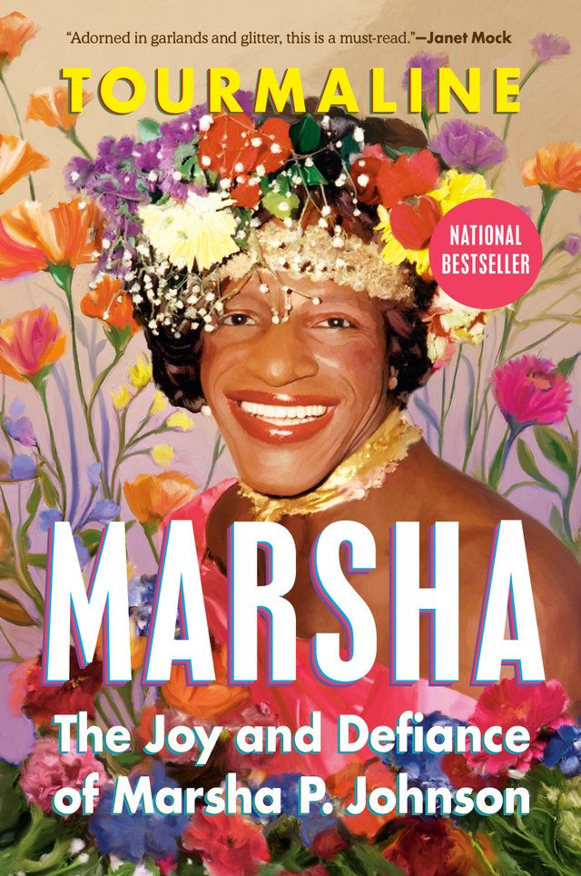 Marsha: The Joy and Defiance of Marsha P. Johnson by Tourmaline, a nonfiction book cover of Marsha P. Johnson smiling wide with pink lipstick, a lush flower crown, a golden cloth choker, and a one-shouldered pink dress. Her image comes from a bed of drawn flowers that also dot the background behind her.