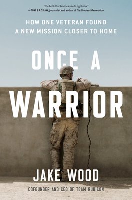 Once a Warrior by Jake Wood book cover with a uniformed man against a cracked half wall with his arms on top and a blue sky in the background.