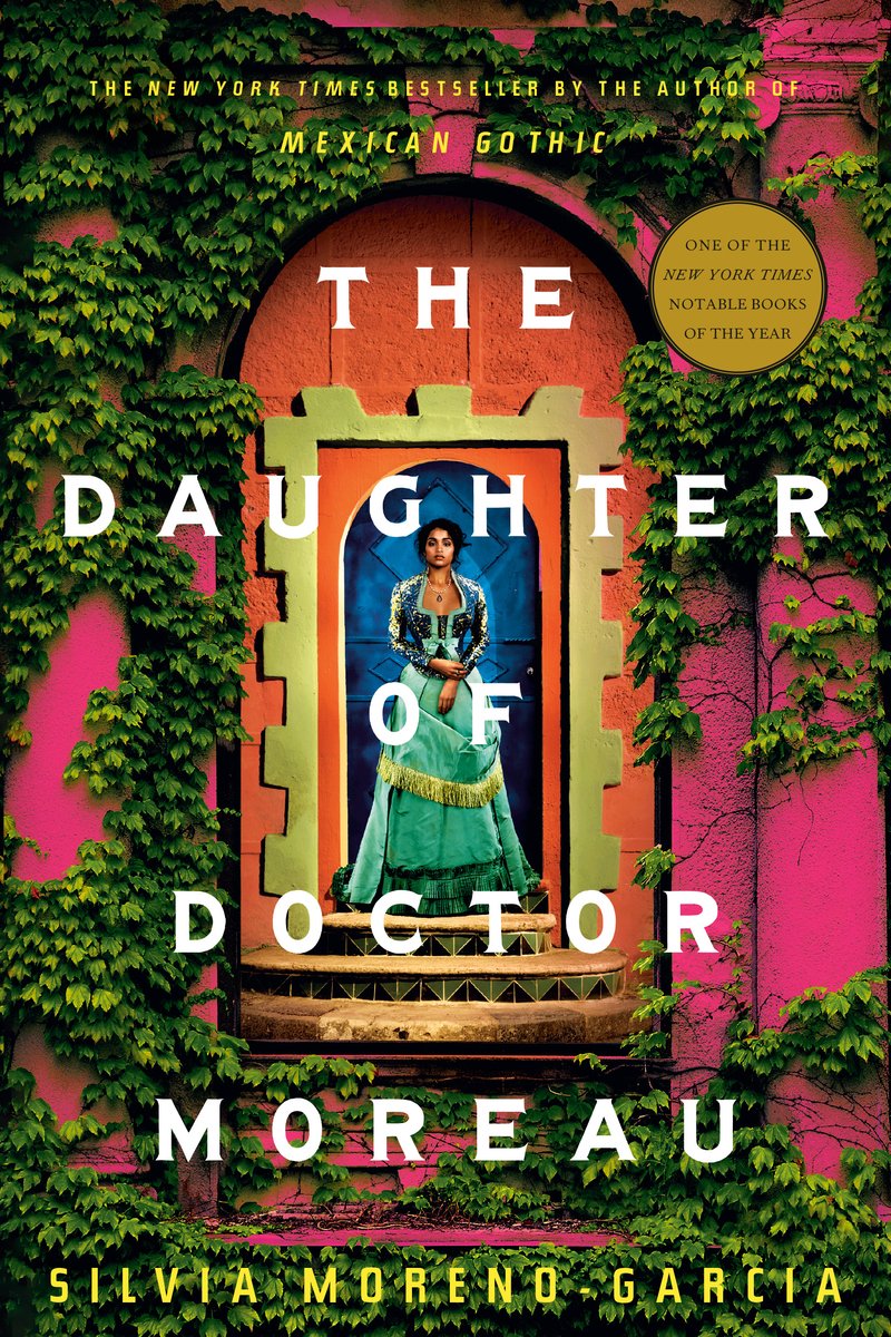 Book cover for The Daughter of Doctor Moreau by Silvia Moreno-Garcia. Image of a young woman standing in an arched blue stone door facing the viewer head-on. She is standing on two tiled steps in an elegant dress. There is an outer orange stone wall that follows the shape of the blue door, and a larger pink wall that is partially covered in ivy.