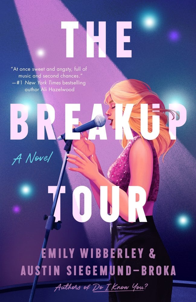 The Breakup Tour by Emily Wibberley and Austin Siegemund-Broka book cover features a spotlighted female singer stands before a microphone, her silhouette illuminated from behind by a soft violet‑pink and blue glow that conveys both glamour and emotional intensity. Large, bold white letters reading “THE BREAKUP TOUR” dominate the upper half of the cover, making the title impossible to miss and hinting at the idea of a tour born from heartbreak. The authors’ names are set just below, in a slightly smaller but still prominent font, anchoring the creative team. Behind the singer, the out‑of‑focus lights and subtle bokeh effects evoke stage lights or paparazzi flashes, giving a sense of fame, audience and spectacle.
