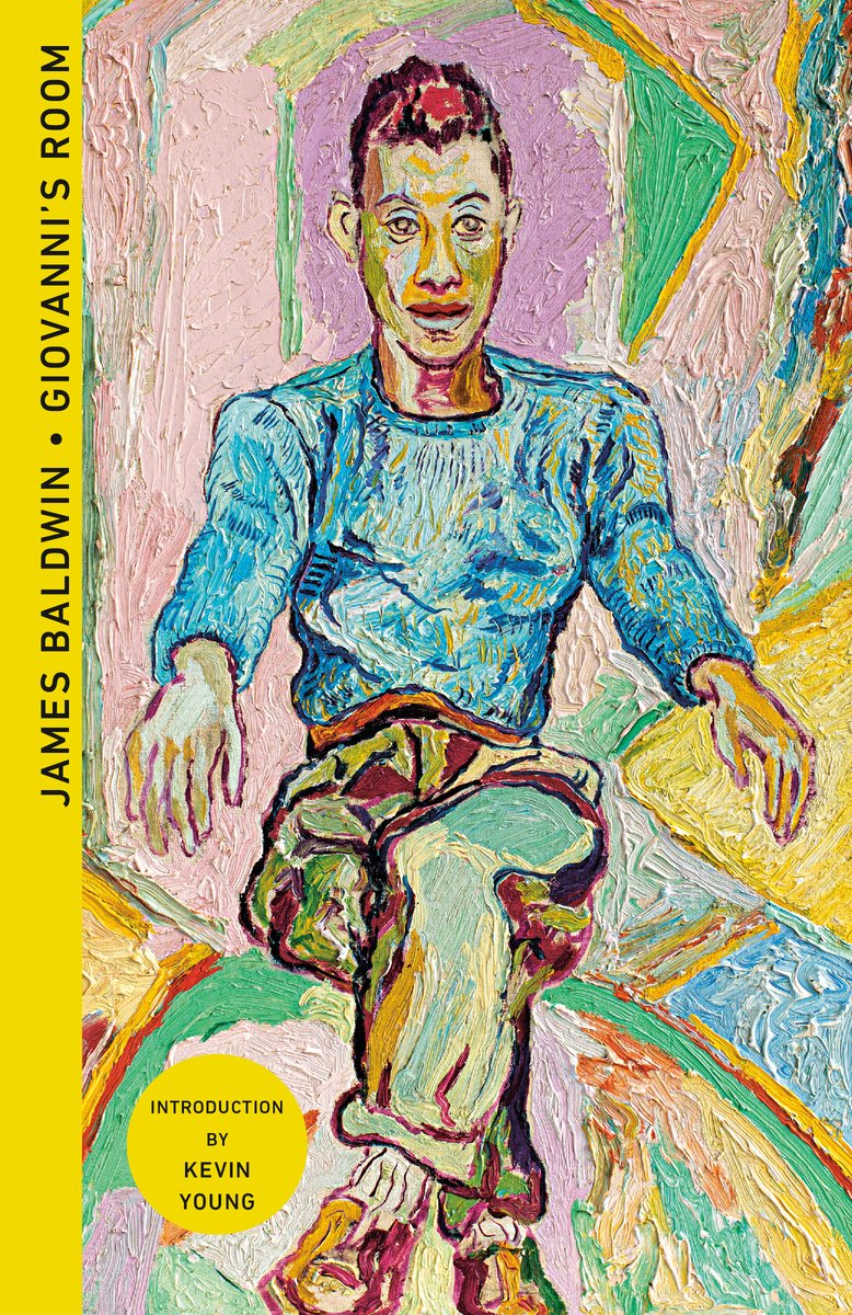 A colourful book cover for Giovanni's Room by James Baldwin depicts a man in a blue jumper, brown trousers, and shoes drawn in a sitting-down position, face-on.