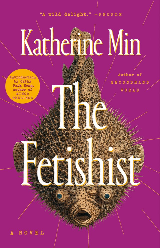 The Fetishist by Katherine Min shows a fugu, also known as a pufferfish, hanging down as gold streaks revolve around it. The violet background makes the fish stand out with the white letting of the title and author's name.