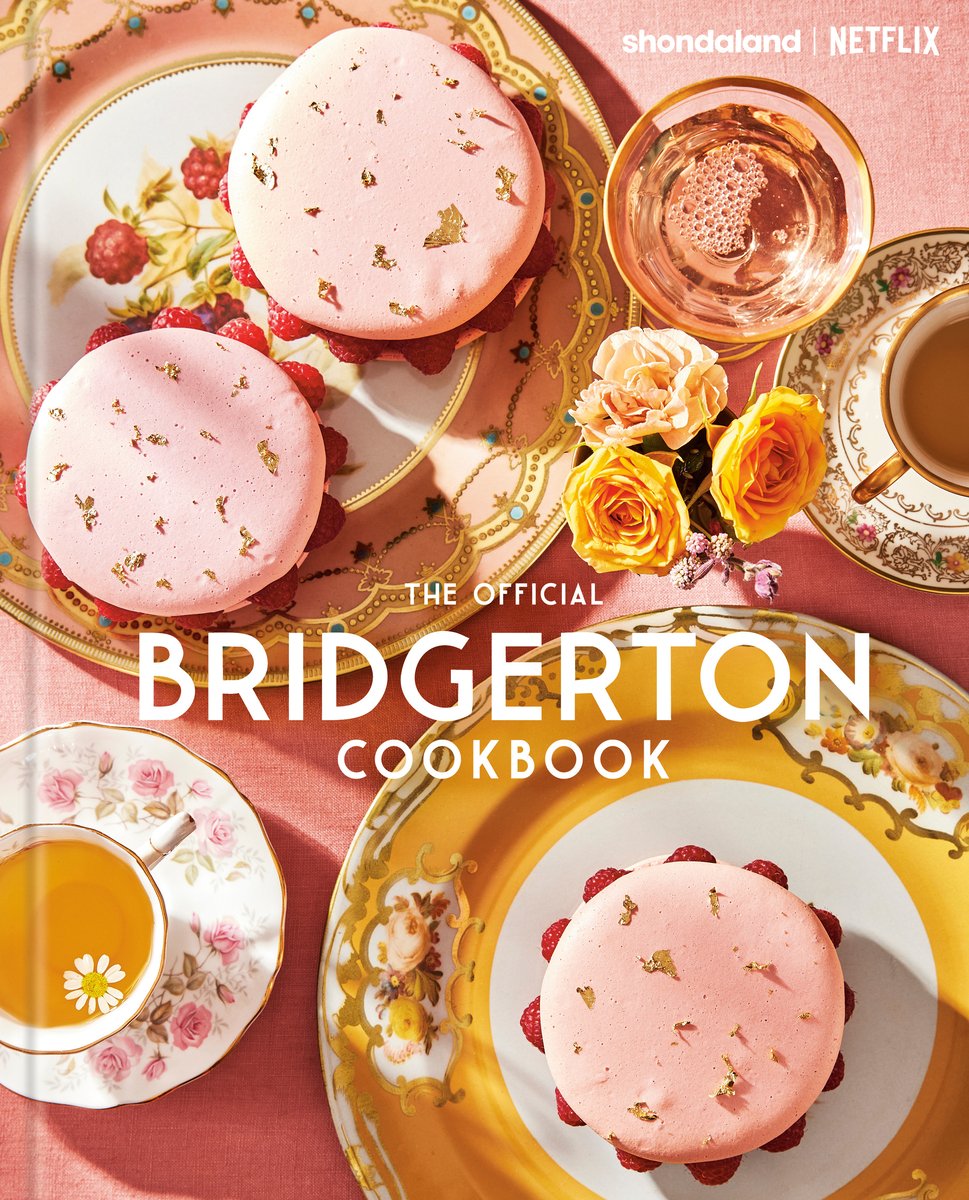The Official Bridgerton Cookbook by Regula Ysewijn book cover. Large macaroons on plates on a pink tablecloth with tea and flowers.