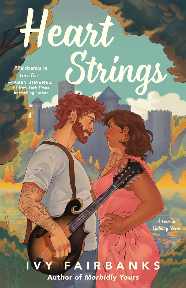 The book cover for Heart Strings by Ivy Fairbanks. An illustration of a castle surrounded by green and golden trees. In the center is a redheaded man with tattoo sleeves wearing a gray t-shirt with a mandolin strung over his shoulder. He reaches out and touches the face of a woman with brown skin and hair wearing a pink dress.