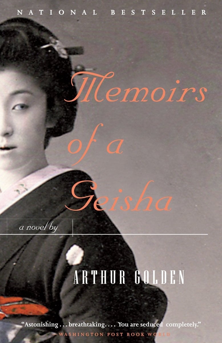 Memoirs of a Geisha by Arthur Golden book cover features half of the profile of a woman, likely a geisha, in black and white. The title is written in red-orange script in the empty space with the author's name at the bottom in all white caps.