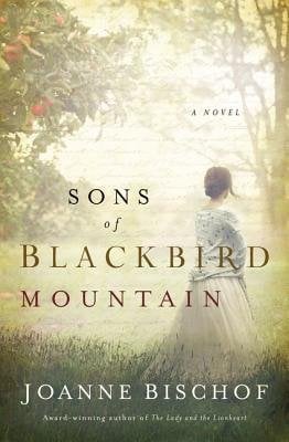 Sons of Blackbird Mountain by Joanne Bischof, book cover. A woman with her back to the viewer in a field, wearing a dress.