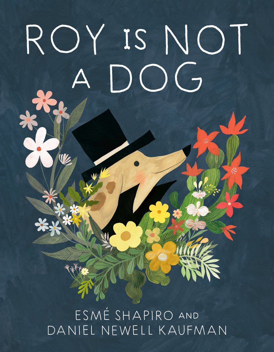 Book cover for Roy is Not A Dog by Daniel Newell Kaufman and Esmé Shapiro. Set on a gray background, the title is in white. Beneath the title, a light brown dog with dark brown spotted ears wears a high necked coat and a top hat. He is smiling and is surrounded by red, pink, white, yellow and tiny blue flowers.
