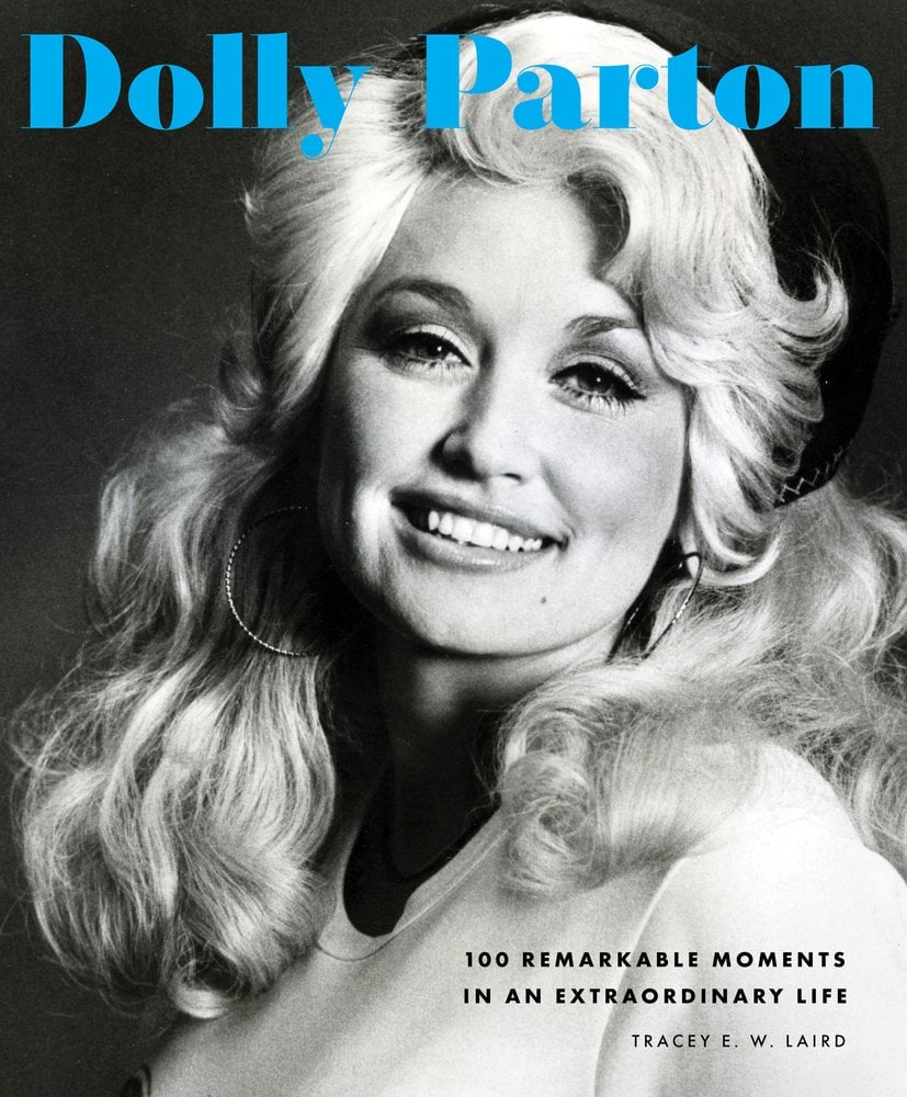 A black and white of Dolly Parton set against a black background. She is smiling and her hair is falling around her face. The title "Dolly Parton" is in blue letters at the top.
