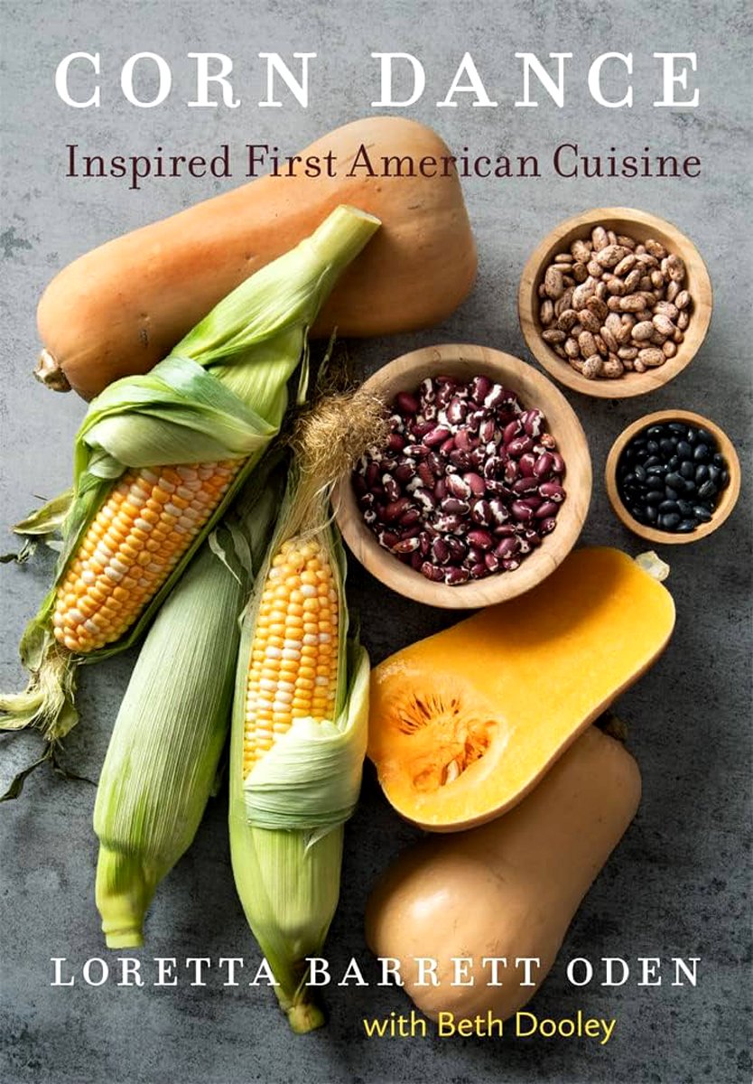 Corn Dance: Inspired First American Cuisine by Loretta Barrett Oden & Beth Dooley, an Indigenous cookbook, cover of squash, corn on the cob, uncooked beans on a white marble countertop.
