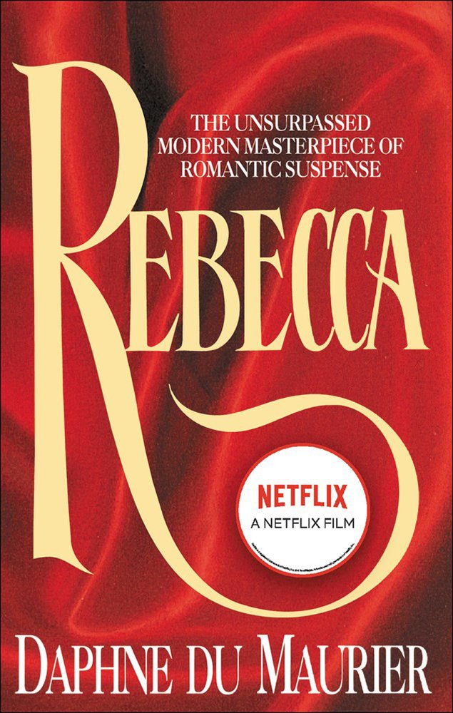 Rebecca by Daphne Du Maurier, red book cover featuring the title in elaborate yellow lettering.