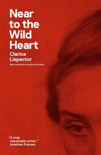 Near to the Wild Heart by Clarice Lispector book cover. An up-close image of the top corner of a woman's face, including her eye, part of her nose, and her hair. The whole image is red.