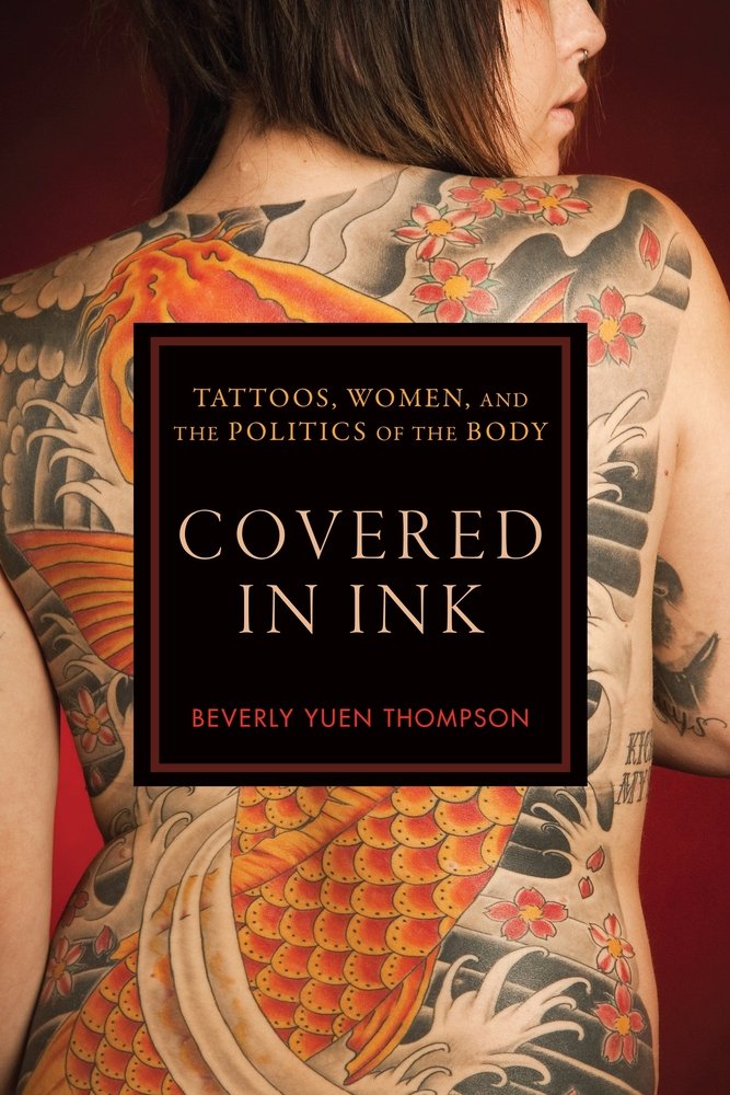 Covered in Ink: Tattoos, Women and the Politics of the Body by Beverly Yuen Thompson shows a fully tattooed woman's back of an orange fish in the sea.