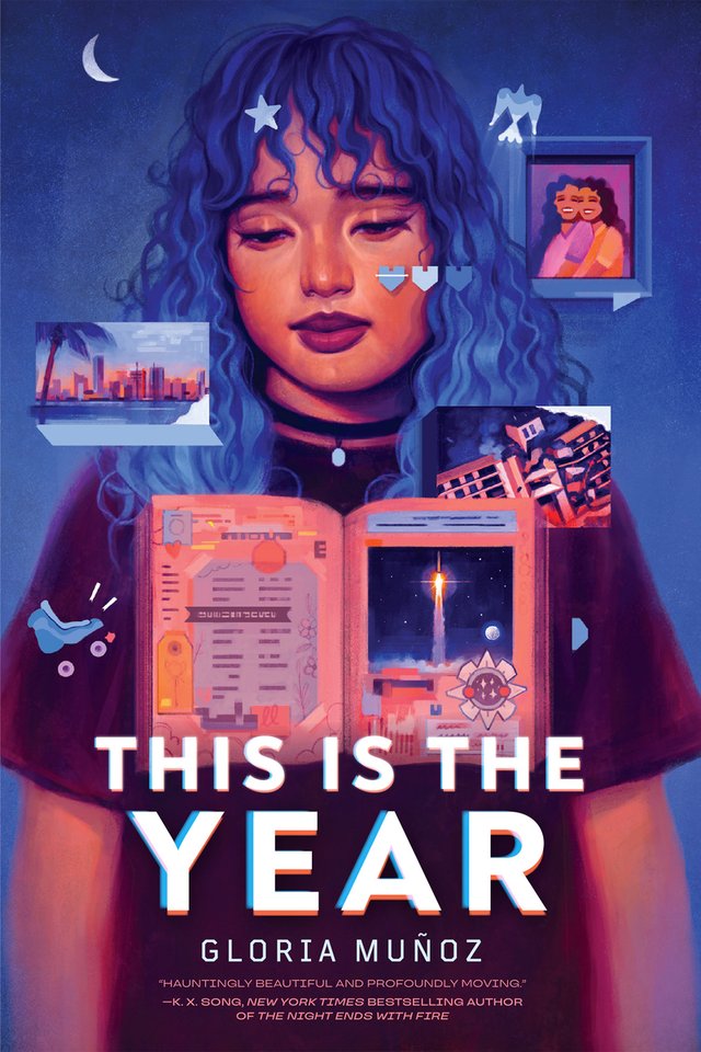 Cover of This Is the Year by Gloria Muñoz. A woman with blue hair and a black top looks down at an open book. The background is blue with a small crescent moon.