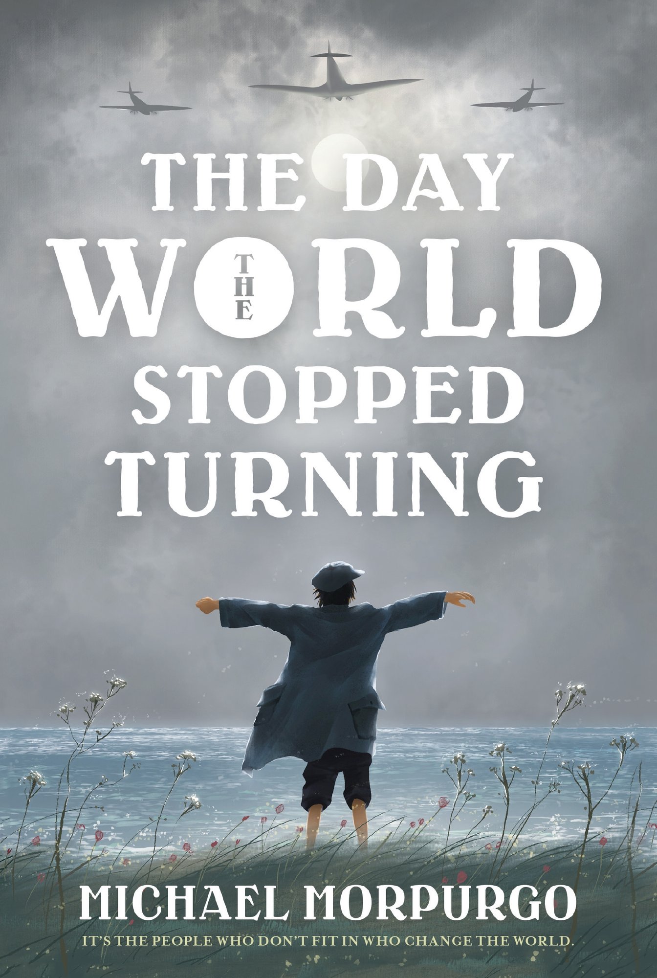 The Day the World Stopped Turning by Michael Morpurgo historical fiction book cover depicting a boy standing in a patch of grass in front of water with his arms spread out and planes flying overhead.