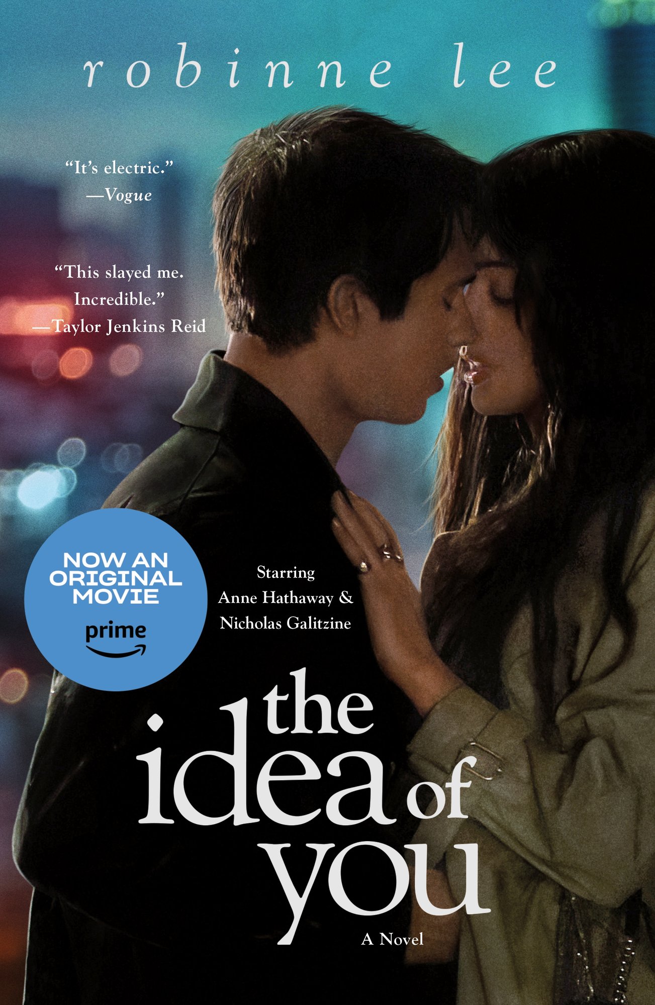 The Idea of You by Robinne Lee book cover features a rich, dreamy palette: purples/pinks fading into night‑sky blue. A man and women are embraced, with the woman's hand placed on the man's chest. Both have dark, brown hair with jackets on. The title is in lowercase, white at the center-bottom and the author's name is in italicized, lowercase white sans-serif with spacing in between the letters at the top.